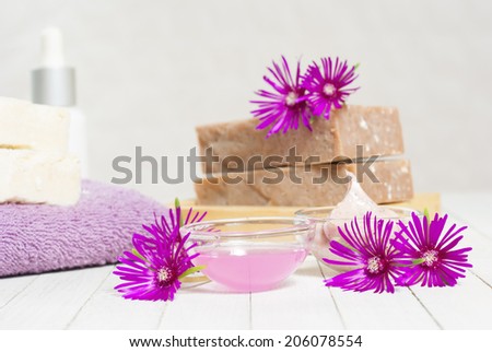 organic soaps and cosmetics with purple flowers on white wooden