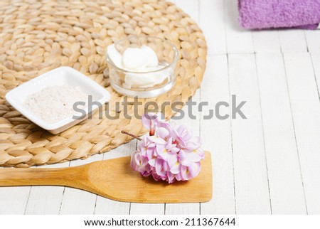 spa setting with pink flowers on white wood