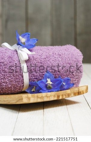 roll up towel with flowers on white wooden table