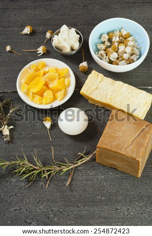 shea butter, bees wax, dried chamomiles, savory twigs and organic soaps on black wood
