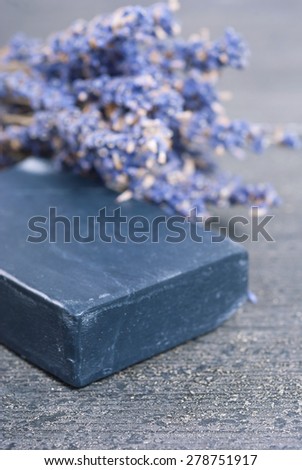 organic soap and a bouquet of dried lavender flowers on dark wooden