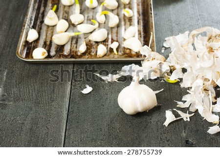 garlic cloves on grill tray, black wood background