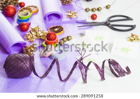 christmas gift packaging with purple papers and cards with christmas tree print