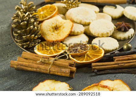 cakes on baking tin with dehydrated citrus fruits and dessert spices on dark rusty wooden table