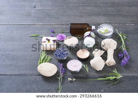 beauty product samples with fresh purple and blue dried lavenders, bath salt, soap on dark wood table background