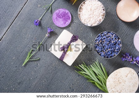 beauty product samples with fresh purple and blue dried lavenders, bath salt, soap on dark wood table background