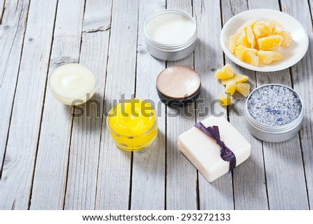 Calendula cream, lip balm, raw bees wax, bath salt soap and other cosmetics on rusty wood table