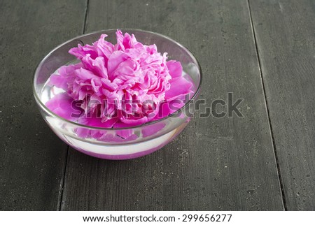 floating flower at aroma bowl on black wooden table
