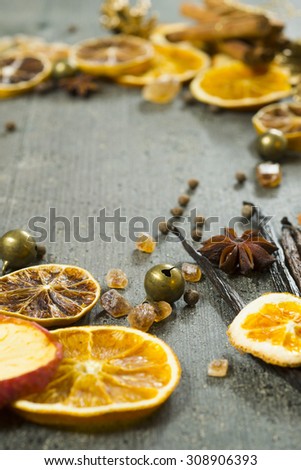 dried dessert spices and golden pine cone christmas decoration on dark wooden table