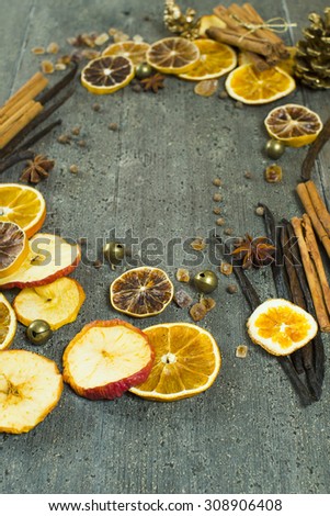 dried dessert spices and golden pine cone christmas decoration on dark wooden table