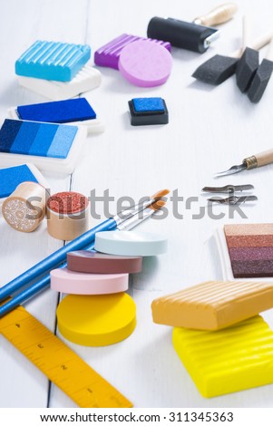 ink pads, brushes and carving cutters on white wood table