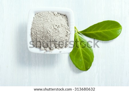 pile of gray cosmetic clay at old white wooden table