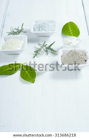 beauty products, cosmetic clay powder, bath salt and cream on white wooden table background