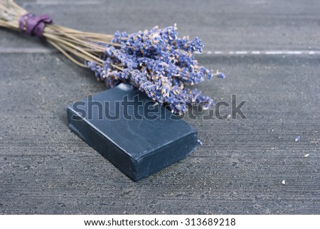 organic soap and a bouquet of dried lavender flowers on dark wooden