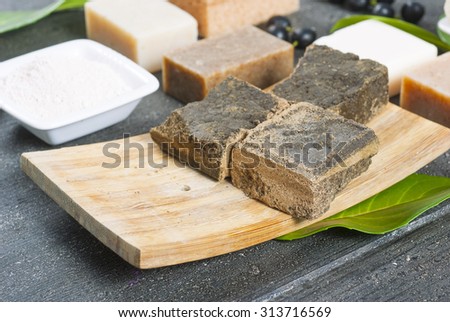 cosmetic clay, soaps, henna blocks, raw shea butter on black wood table
