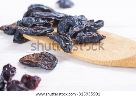 dried cherry and plum fruits on white wood