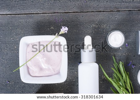 cosmetic creams with fresh lavender flowers on black wooden table