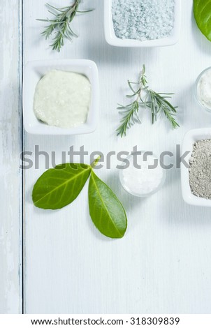 beauty products, cosmetic clay powder, bath salt and cream on white wooden table background