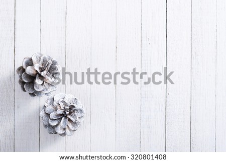 snow painted pine cones on rustic white wood table, Christmas decoration background