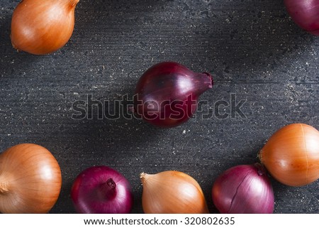 spanish and red onions on black wooden table
