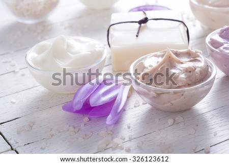 cosmetic cream variations, soap and autumn crocus herbal flower on white wooden table
