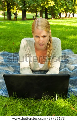 blond woman with notebook in park