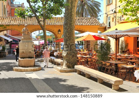 MENTON - JUNE 13: Plaza with bars and restaurants in the shade of trees and small statue in the center of a town on French Riviera - popular tourist resort in Menton, France on June 13, 2013.