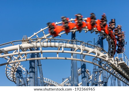 Roller coaster ride under blue sky.