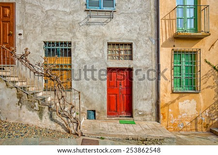 Facade of typical italian house with colorful windows and doors in town of Saluzzo in Piedmont, Northern Italy.
