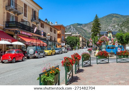 TENDE, FRANCE - AUGUST 12, 2014: Restaurants and bars along narrow road through Tende - small tourist town in French Alps, located on old route of salt trade and known for its cheese, honey and jams.