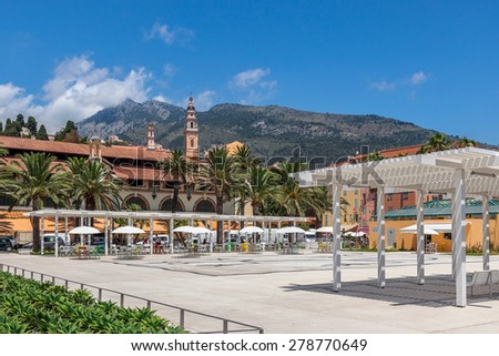 Small square and colorful houses under blue sky in Menton - town on French Riviera.
