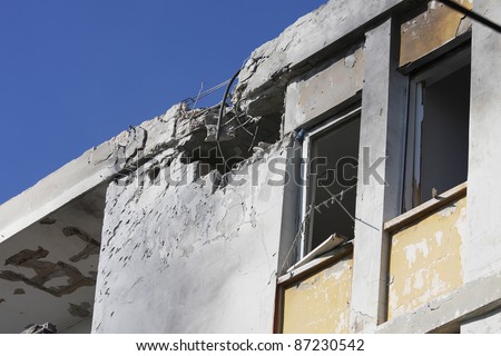 Hole and broken windows in the apartment building caused by explosion of missile launched by Hamas terrorists.