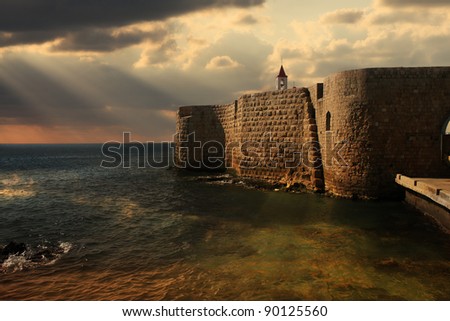 View on Mediterranean sea and ancient walls of Acre at sunset in Israel.