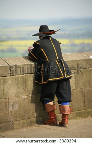 man in period costume looking over wall