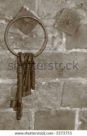 old keys hanging on hook in sepia