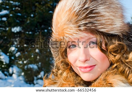 portrait of young smiling woman in fur cap