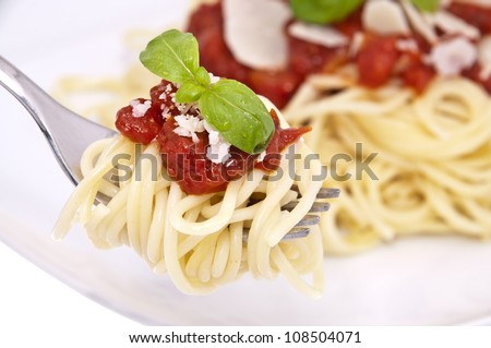 Spaghetti with tomato sauce, basil and parmesan cheese on a fork