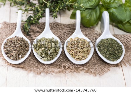 Small portions of fresh Herbs (macro shot on white wooden background)