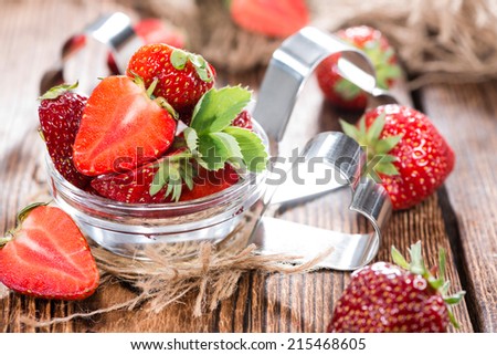 Portion of Strawberry Pieces with some fresh fruits (close-up shot)