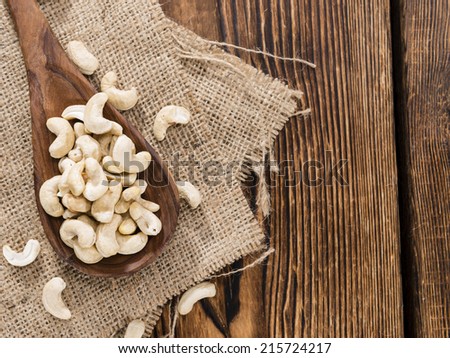 Dried Cashew Nuts on wooden background (close-up shot)