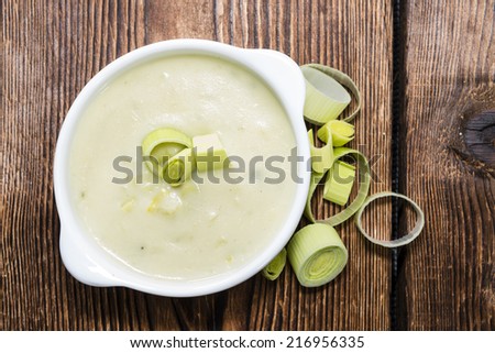Leek Soup (fresh made) in a bowl on wooden background
