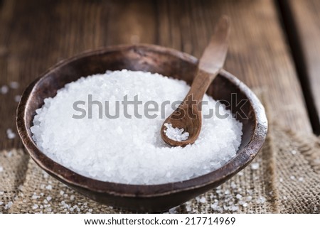 Heap of Salt (close-up shot) on dark wooden table
