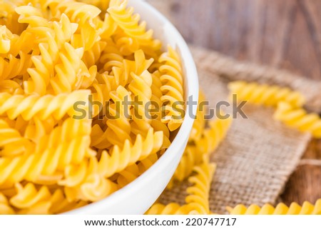 Portion of uncooked Pasta (Fussili) on rustic wooden background