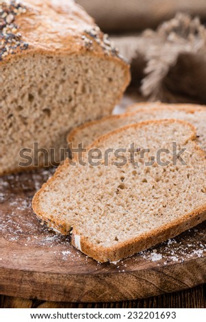 Fresh baked bread with seeds on rustic wooden background