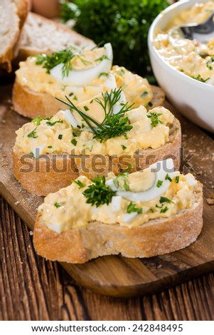 Portion of Egg Salad (fresh homemade with herbs) on wooden background