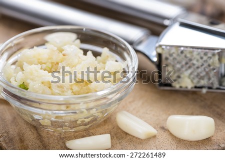 Crushed Garlic (close-up shot) on rustic wooden background