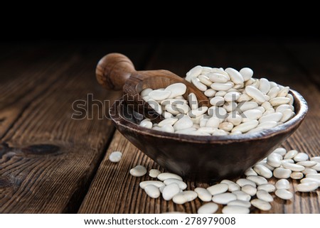 Some White Beans on a rustic wooden background (close-up shot)