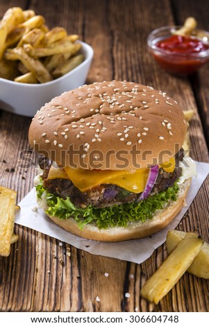 Homemade Beef Burger with Cheese and Chips on wooden background