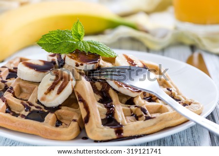 Breakfast table (Waffles with Bananas and Chocolate Sauce as close-up shot)