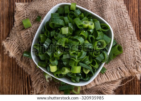 Portion of fresh Scallions (detailed close-up shot) on vintage wooden background